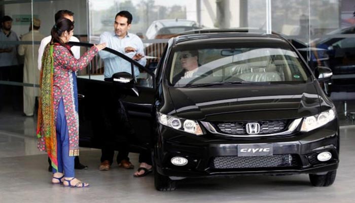 In this file photo, a customer speaks with a salesman at a car dealership in Rawalpindi on June 18, 2016. — Reuters