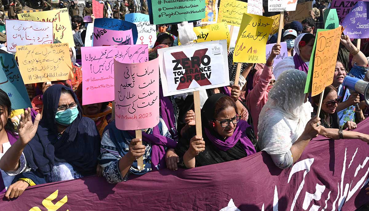 Participants of Aurat March hold placards during a rally in Lahore. — AFP