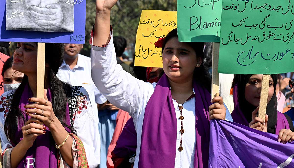 Orang-orang memegang plakat selama rapat umum di ibu kota Punjab.  —AFP
