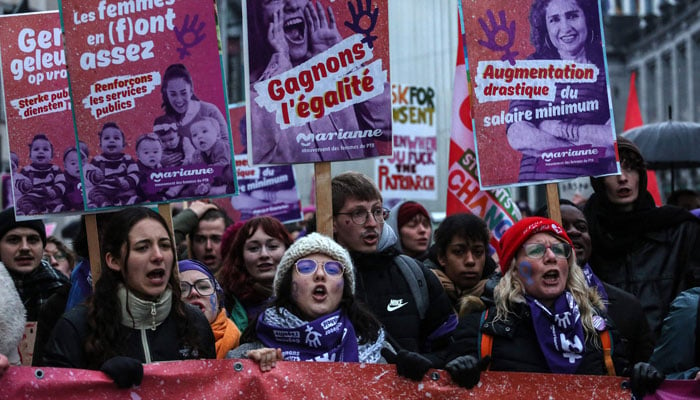 Women hold placard during a rally to mark the International Women´s Day in Brussels on March 8, 2023. AFP