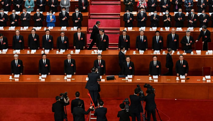 State media staff members work as Chinas President Xi Jinping (C) and other Chinese leaders arrive for the opening session of the National Peoples Congress (NPC) at the Great Hall of the People in Beijing on March 5, 2023. — AFP