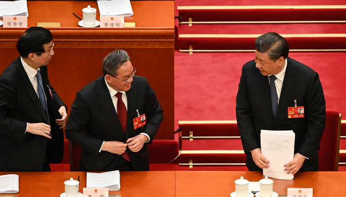 President Xi Jinping (R) speaks with Politburo Standing Committee member Li Qiang (C) after the second plenary session of the National Peoples Congress (NPC) at the Great Hall of the People in Beijing on March 7, 2023. — AFP