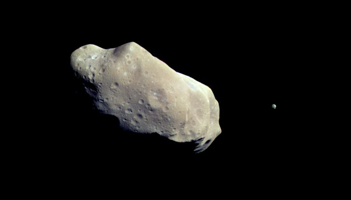 A large, cratered, lumpy asteroid, along with a tiny moonlet companion, against the stark blackness of space. — Twitter/NASASolarSystem/File