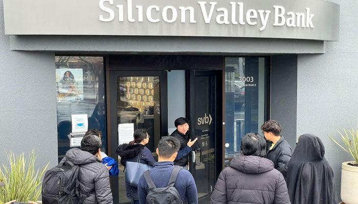 A worker tells people that the Silicon Valley Bank headquarters is closed in Santa Clara, California, on Friday. AFP/File