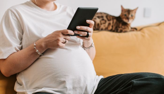 A pregnant woman using her phone.— Pexels