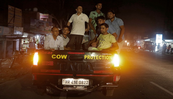 A group of cow vigilantes prepare to set up a roadblock, accompanied by police, near the northern Indian city of Chandigarh in early July. — Reuters/File
