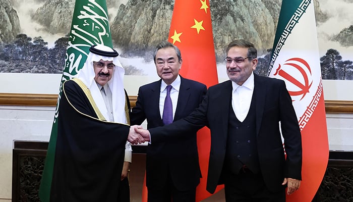 Saudi Arabias Musaad bin Mohammed Al Aiban (left), China’s top diplomat Wang Yi and Irans Ali Shamkhani stand together in Beijing on Friday. — Reuters