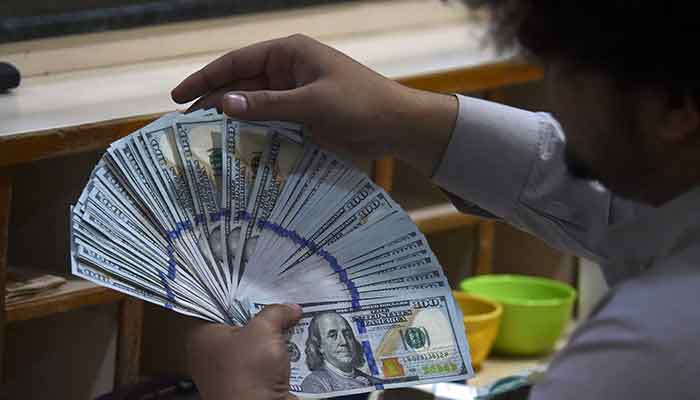 Rupee to recuperate in coming week on hopes of IMF deal 2 A dealer counts US dollars at a money exchange market in Karachi on January 26, 2023. — AFP