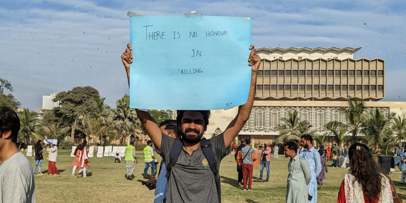 A boy holding a poster at Aurat March 2023 on March 12, 2023. — Photo by author