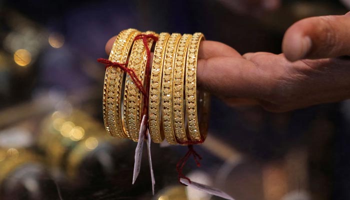 An undated image of a goldsmith showing gold bangles. — Reuters/File