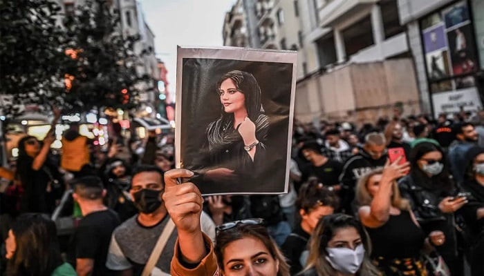 A protester holds a portrait of Mahsa Amini during a demonstration in support of Amini, a young Iranian woman who died after being arrested in Tehran by the countrys morality police, on Istiklal avenue in Istanbul on September 20, 2022. — AFP/File