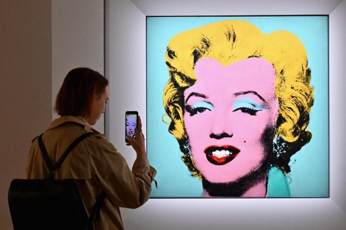A woman takes a photo of Andy Warhols ‘Shot Sage Blue Marilyn’ during Christies 20th and 21st Century Art press preview at Christies New York on April 29, 2022, in New York City. The painting fetched $195 million. —AFP/File