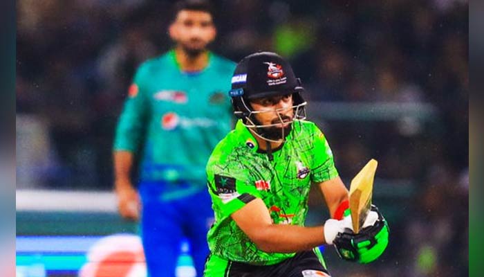 A Lahore Qalandars batter hits a shot while a Multan Sultans fielder looks on during the 20th fixture of the ongoing season of the Pakistan Super League (PSL) on March 4, 2023. — PSL