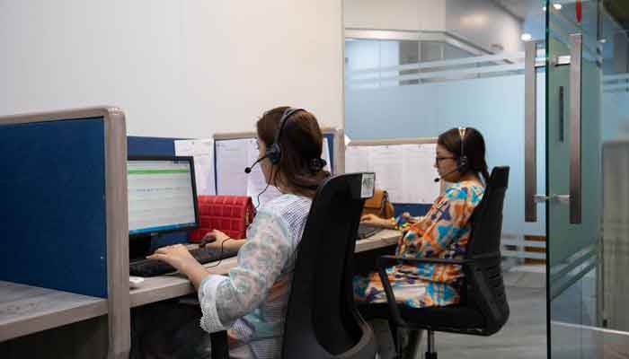 Employees at health tech company Sehat Kahani answer calls at the main office in Karachi, Pakistan on April 14, 2022. — Reuters