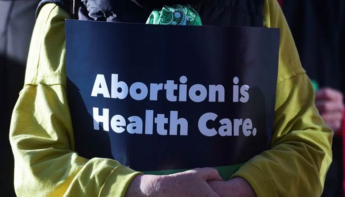 A protester holds an “abortion is healthcare” sign during the Womens March protest outside of the Federal Courthouse in Amarillo, Texas on March 15, 2023. — Reuters
