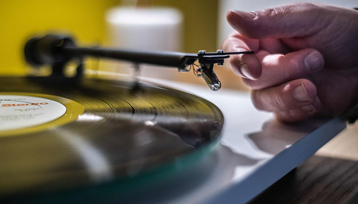 (FILES) In this file photo taken on February 18, 2020, a man plays a turntable vinyl record player in a music store in Paris. —AFP