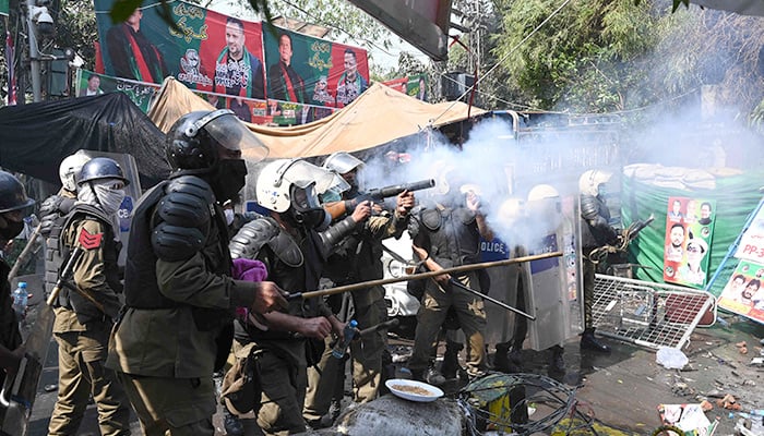 Riot police fire tear gas shells towards supporters of former prime minister Imran Khan gathered near Khans house to prevent officers from arresting him, in Lahore on March 15, 2023. — AFP