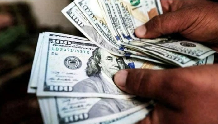 A file photo of a man counting US dollar bills. Photo: AFP