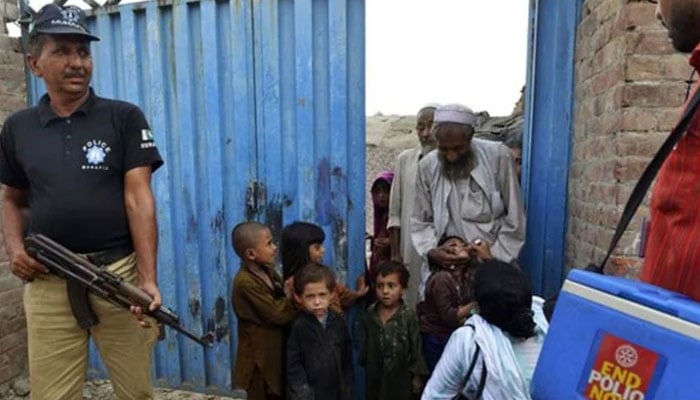 A polio worker administers vaccine to children. — AFP/File