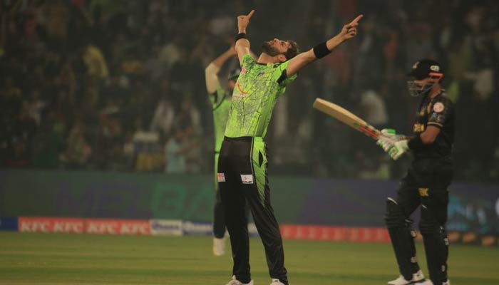 Lahore Qalandars Captain Shaheen Afridi celebrates while a Peshawar Zalmi batter looks on during the 15th fixture of the Pakistan Super League (PSL) at the Gaddafi Stadium in Lahore on February 26, 2023. — PSL