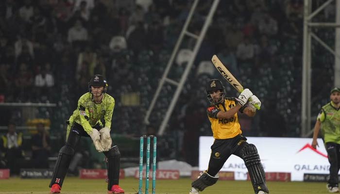 Peshawar Zalmi batter hits a shot as Lahore Qalandars wicketkeeper looks on during the second eliminator of the Pakistan Super League (PSL) at the Gaddafi Stadium in Lahore on March 17, 2023. — PSL