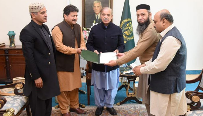 Prime Minister Shehbaz Sharif hands over the allotment letter of a residential plot to the heirs of Qazi Abdur Rehman Amritsari.
