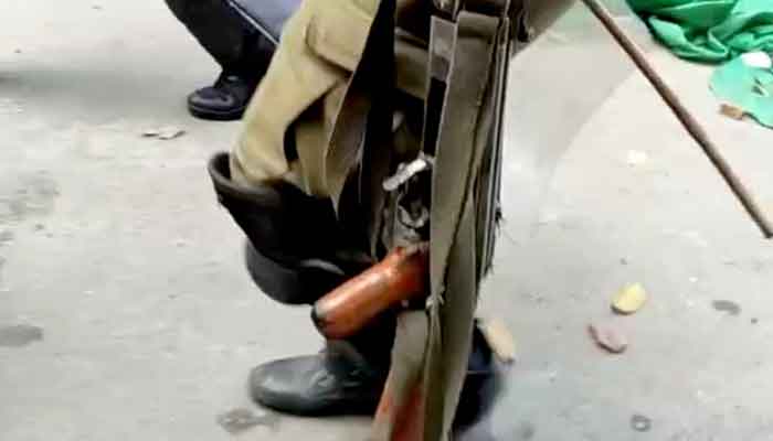 A policeman carries a rifle allegedly recovered from Imran Khan's residence. — Geo News