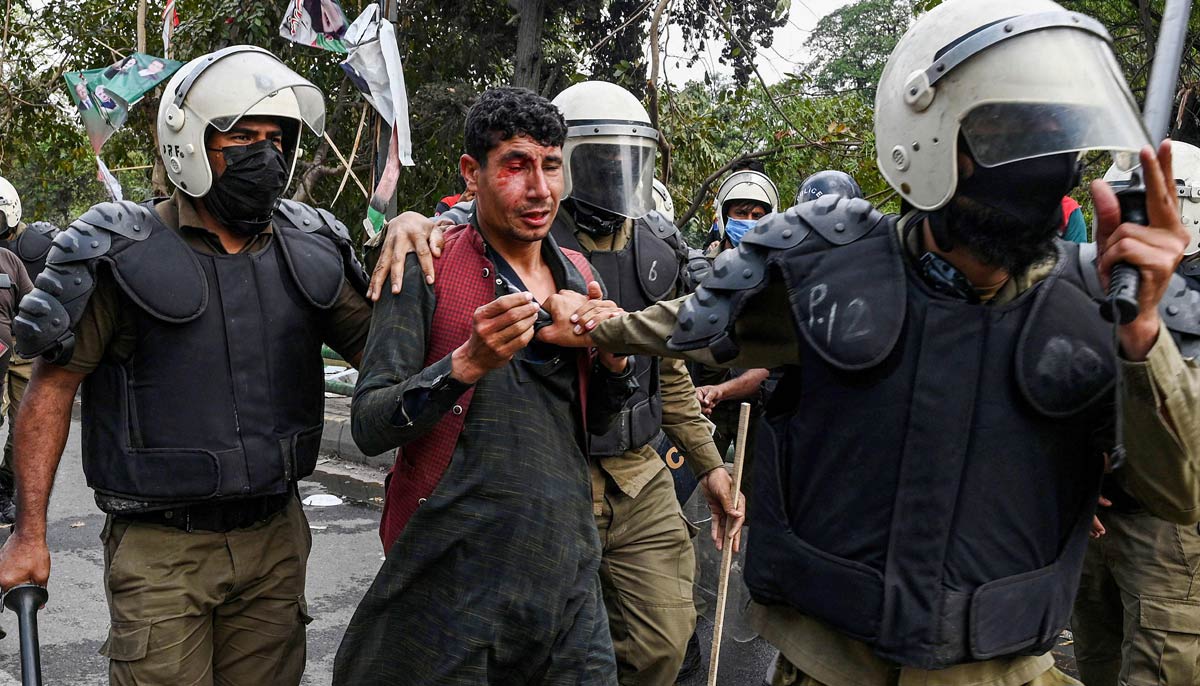 Riot police detain a supporter of Khan outside his residence in Lahore on March 18, 2023. — AFP