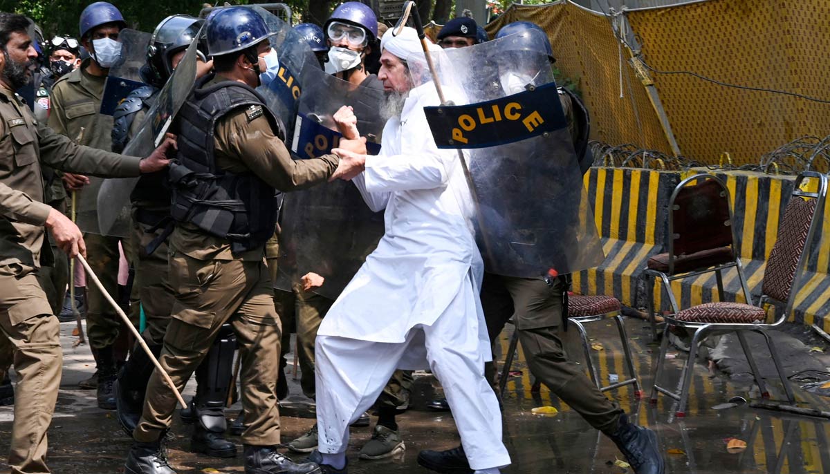 Riot police detain a supporter of Khan outside his residence in Lahore on March 18, 2023. — AFP