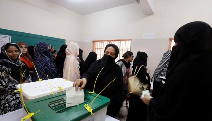 A woman casts her ballot while other wait for their turn at a polling station during the general election in Karachi, Pakistan, July 25, 2018. — Reuters