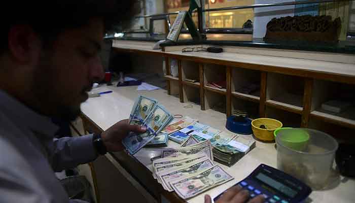 A dealer holds US dollars at a money exchange market in Karachi on January 26, 2023. — AFP