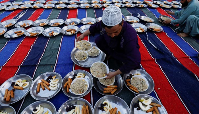 A man arranges plates of food for iftar during the fasting month of Ramadan, as the COVID-19 outbreak continues, at a mosque in Karachi, Pakistan, April 14, 2021. — Reuters