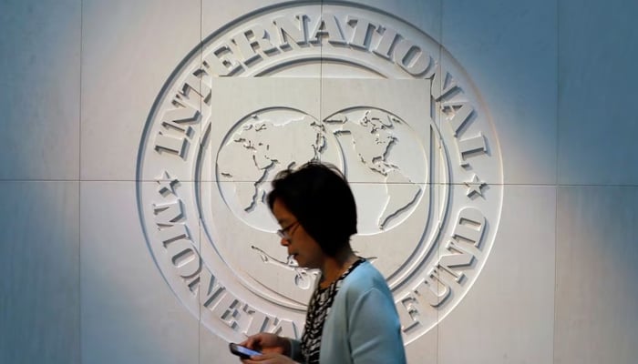 A woman walks past the International Monetary Fund (IMF) logo at its headquarters in Washington, US. — Reuters/File