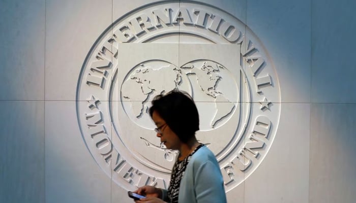 A woman walks past the International Monetary Fund (IMF) logo at its headquarters in Washington, US. — Reuters/File