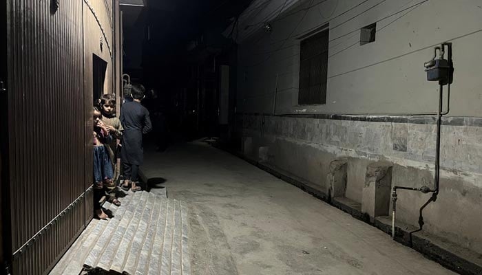 21 مارچ 2023 کو پشاور، پاکستان میں زلزلے کے جھٹکے محسوس کیے جانے کے بعد بچے اپنے گھر کے دروازے پر کھڑے ہیں۔ - رائٹرز