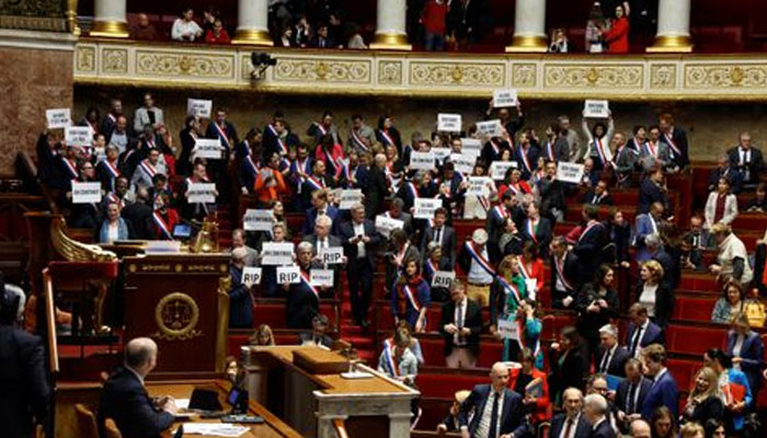 Members of parliament of the left hold placards after the result of the vote on the first motion of no-confidence against the French government, tabled by centrist group Liot, after the use by French government of the article 49.3, a special clause in the French Constitution, to push the pensions reform bill through the National Assembly without a vote by lawmakers, at the National Assembly in Paris, France, March 20, 2023. —Reuters