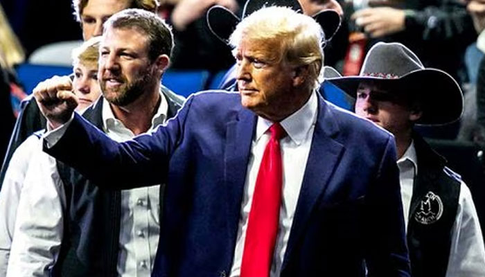 Former US President Donald Trump greets fans as he arrives before the finals during the sixth session of the NCAA Division I Wrestling Championships at BOK Center in Tulsa, Oklahoma, U.S. March 18, 2023.—Reuters