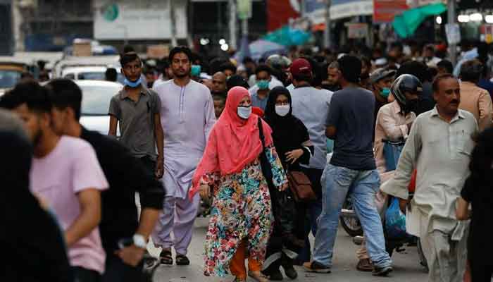 Women wearing protective face masks walk amid the rush of people along a road as the outbreak of the coronavirus disease (COVID-19) continues, in Karachi, Pakistan July 20, 2020. — Reuters