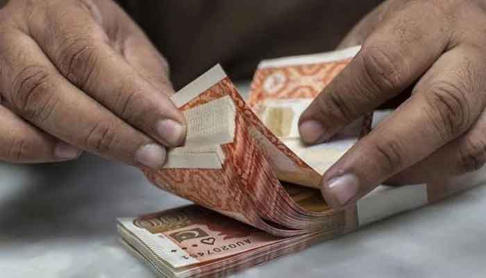 An undated image of a currency dealer counting Rs5,000 notes. — AFP/File