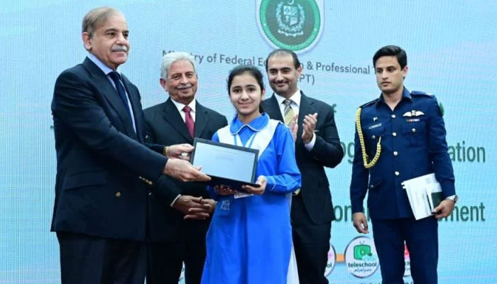 Prime Minister Shehbaz Sharif hands over a laptop to a student on March 21. — APP
