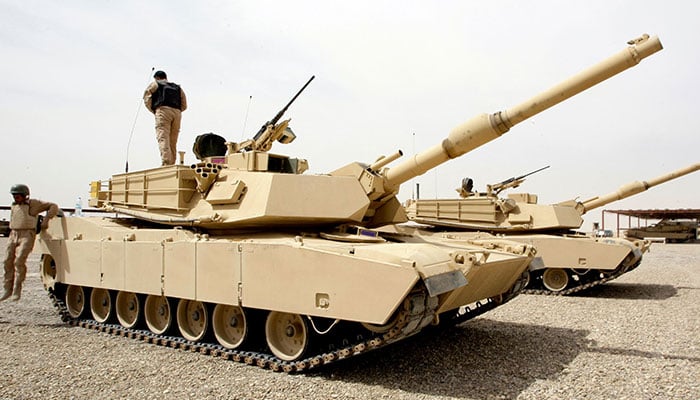 In this file photo taken on March 15, 2010 an Iraqi soldier stands atop an Abrams-M1A1 tank while another one jumps onto the ground during a training session with US troops on using the US-made main battle tanks at the joint Iraqi-American military base of Basmaya on the southern outskirts of Baghdad on March 15, 2010.— AFP