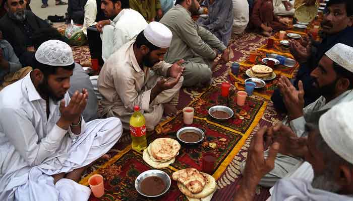 Pakistani residents offer prayers before breaking their fast in Peshawar on June 8. — AFP