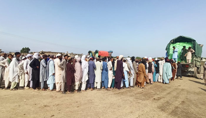 People line up to collect free government wheat in Dera Ismail Khan. — Twitter/DfcDikhan