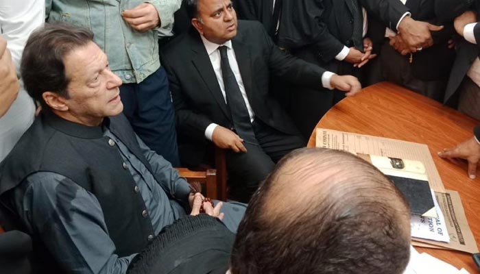 Former prime minister Imran Khan (L) sits inside the courtroom as a two-member special bench, hearing his plea to determine whether the bail is maintainable or not on March 24, 2023. — PTI