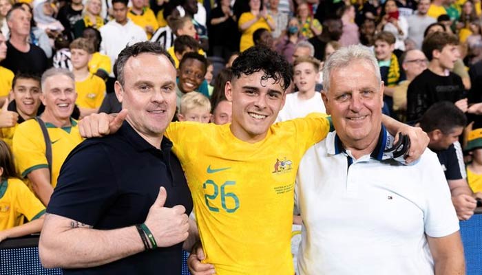 Alex Robertson (centre) poses with his father and grandfather following the Socceroos game on March 24, 2023. — Twitter/@Sachk0