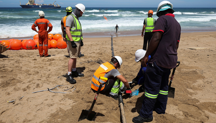 Workers toil on the 2Africa undersea cable project in Amanzimtoti, South Africa on Feb. 7, 2023. — Reuters