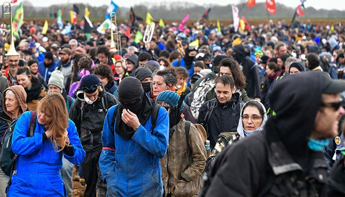 Protesters walk in a field during a demonstration called by the collective Bassines non merci, the environmental movement Les Soulevements de la Terre and the French trade union ´Confederation paysanne´ to protest against the construction of a new water reserve for agricultural irrigation, in Sainte-Soline, central-western France, on March 25, 2023.—AFP