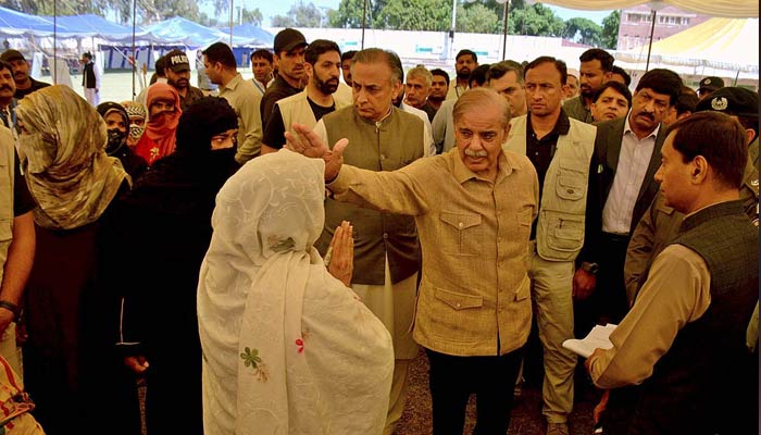 Prime Minister Shehbaz Sharif is talking to people at the free flour distribution point set up at Bahawalpur Stadium on March 26, 2023. — APP