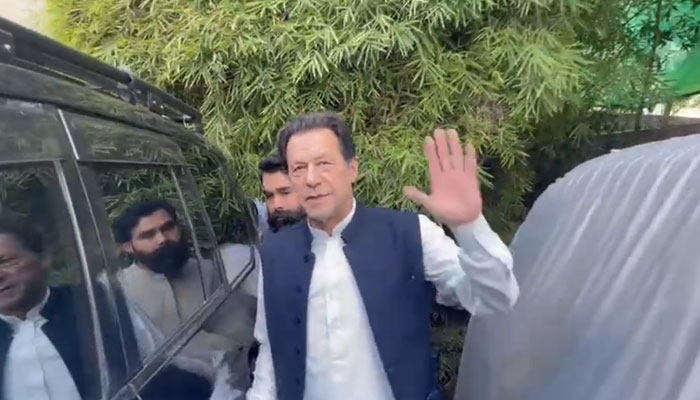 Pakistan Tehreek-e-Insaf (PTI) Chairman Imran Khan waves before sitting in his car at his Zaman Park residence in Lahore. — Screengrab/Twitter/@MusarratCheema