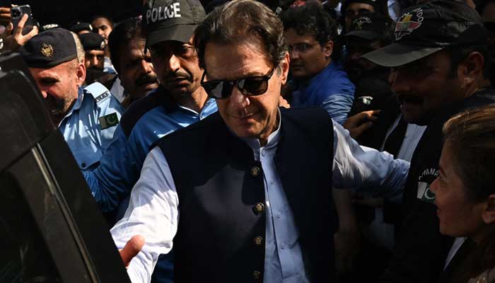 PTI Chairman Imran Khan pictured before sitting in a car amid strict security outside a court in Islamabad. — AFP/File